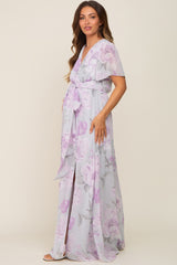 Woman wearing a light purple floral maternity maxi dress with short sleeves and a waist tie