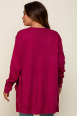 Back view of a woman wearing a long magenta knit cardigan with side pockets