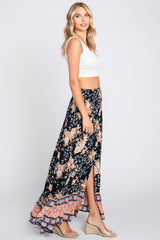 woman wearing white crop top and navy floral maxi skirt with side slit and wedge sandals