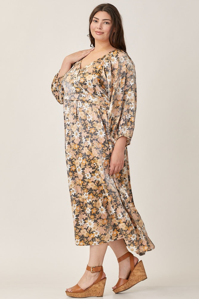 plus size woman wearing a floral v-neck midi dress and tan wedge sandals