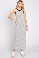 woman wearing a sleeveless black and white striped maxi dress with white platform sneakers