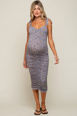 pregnant woman wearing a floral ruched maternity midi dress with tie straps and black sandals