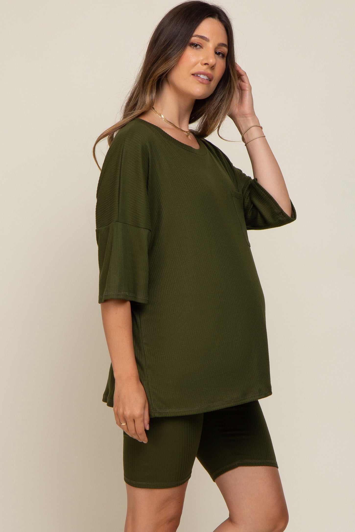 pregnant woman wearing olive green ribbed maternity lounge set with short sleeve top and biker shorts