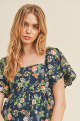 woman wearing a navy floral puff sleeve dress with a square neckline and loose fit