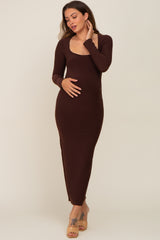 woman wearing a long sleeve brown maternity maxi dress with a scoop neckline