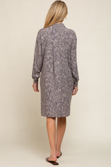 Back view of a woman wearing a long sleeve grey floral print shirt dress with a collared neckline