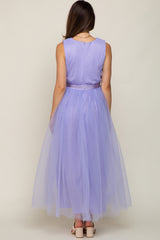 Back view of a woman wearing a sleeveless lavender maxi dress with a tulle skirt and satin waist tie