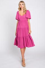 Blonde woman wearing a magenta tiered midi dress with flutter sleeves and tan platform sandals