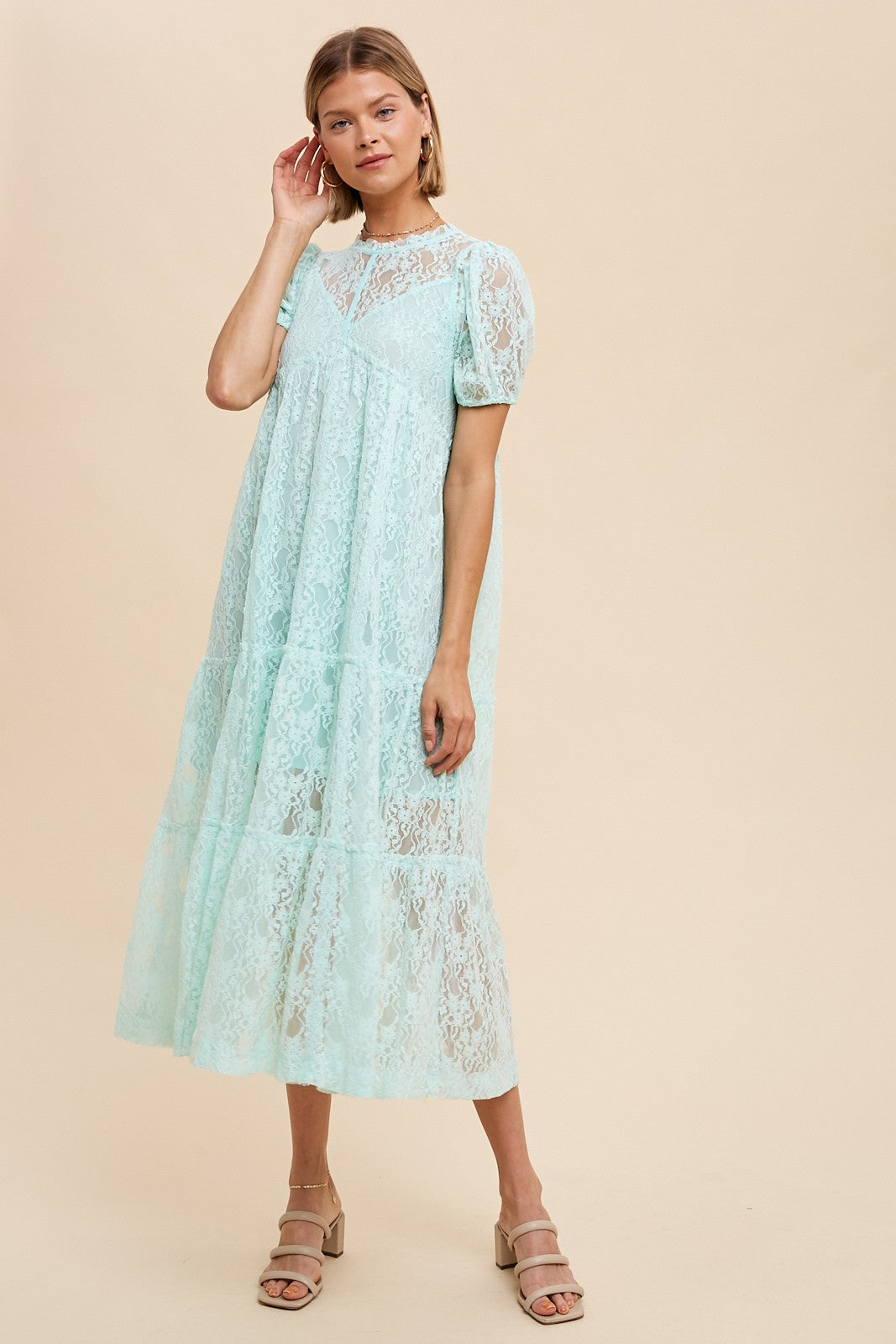 woman wearing a light blue lace tiered midi dress with puff sleeves and tan block heel sandals