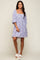 Woman wearing a lavender floral puff sleeve mini dress with square neckline and white platform sandals