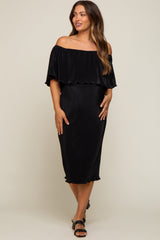 woman wearing a black off the shoulder pleated maternity midi dress with ruffled neckline