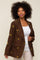 Woman wearing a brown corduroy blazer with yellow floral embroidery over a white tank top