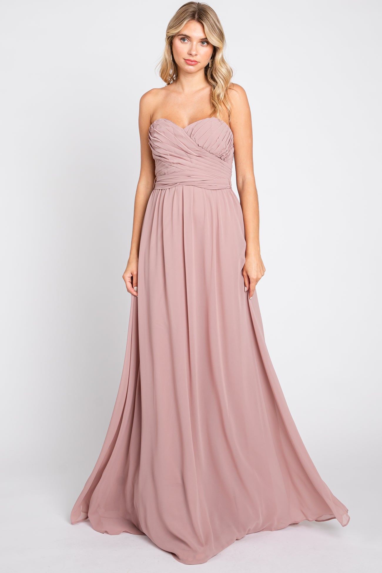 woman wearing a blush strapless long gown with ruching details and flowing skirt