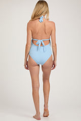 woman wearing a light blue maternity swimsuit with back ties and ribbed texture