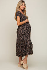 Pregnant woman wearing a black floral maternity midi dress and woven platform sandals