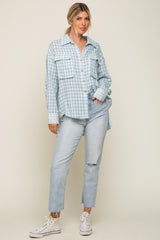 woman wearing light blue gingham button down shirt and distressed denim jeans with white sneakers