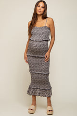 woman wearing a black floral maternity dress with ruffles and a visible baby bump
