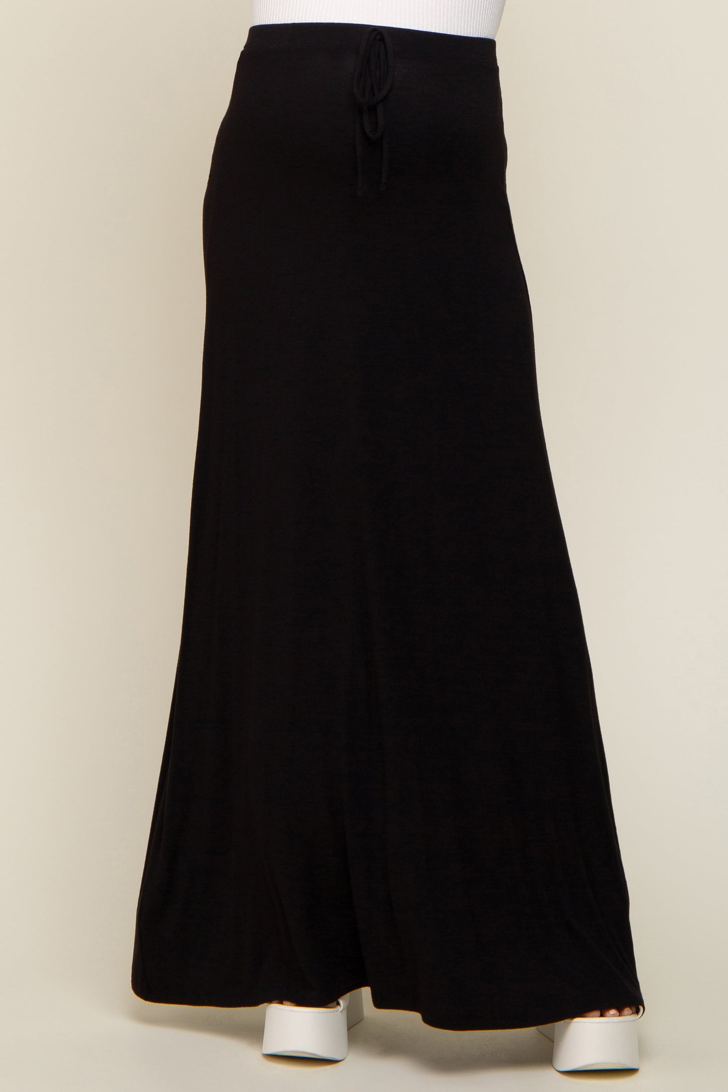 person wearing a long black drawstring maxi skirt with white platform sandals