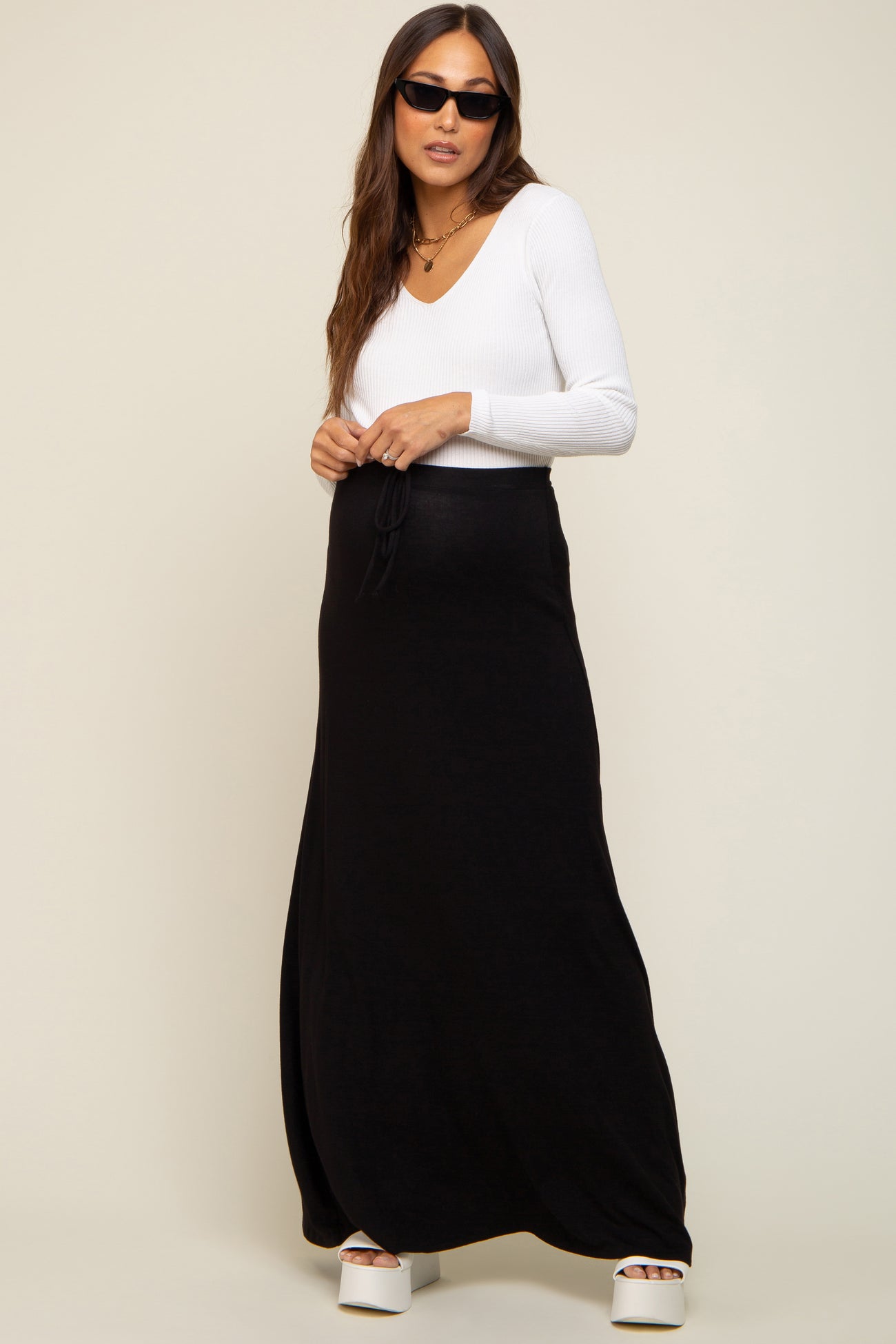 woman wearing white long sleeve v-neck top and black maternity maxi skirt with drawstring waist