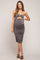 woman wearing a gray maternity dress with a cutout and ruching, showcasing her baby bump