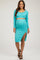 woman wearing a aqua long sleeve maternity crop top with matching midi skirt featuring a side slit and showing her baby bump