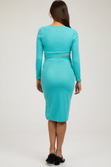woman wearing a teal ribbed maternity knit top and matching pencil skirt, showing a baby bump from the back