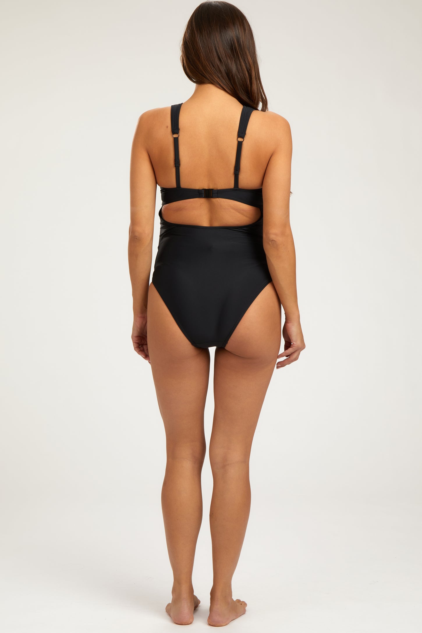 woman wearing a black maternity swimsuit with adjustable straps and a low back design