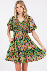 woman wearing a vibrant floral print short dress with puff sleeves and a smocked bodice, posing with one hand on her waist