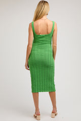 woman wearing a medium green ribbed knit maternity dress with a midi length and scoop back