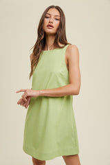 woman wearing a sleeveless light green shift dress with a relaxed fit